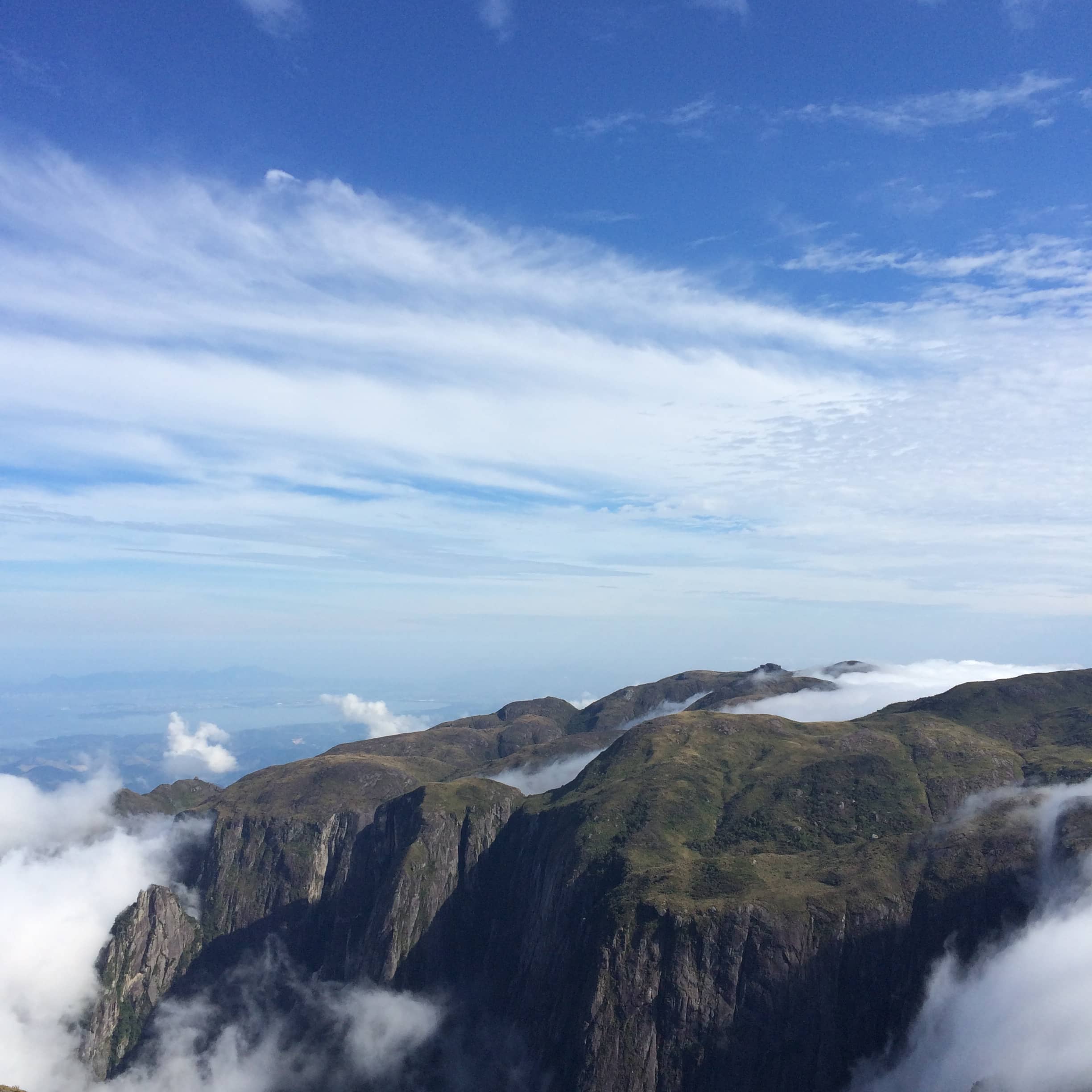 A broad mountain plateau rises above a bank of low white clouds.