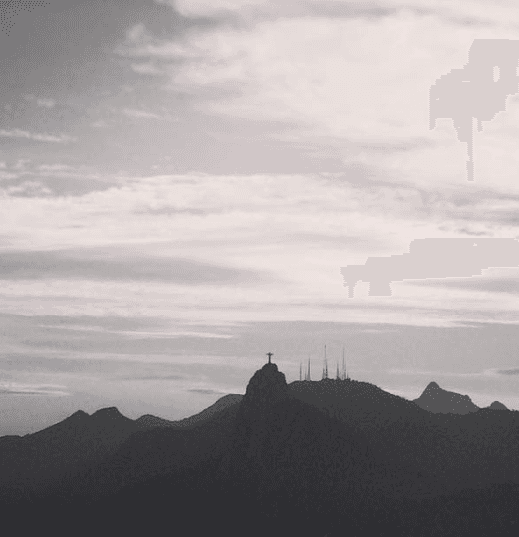 Dark mountain ridges recede beneath a pale, cloud-streaked sky.