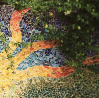 An orange and yellow mosaic pattern appears among small tiles and foliage.